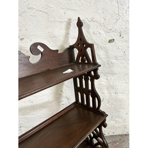 106 - A George III style carved mahogany wall mountable three tier shelf with two lower drawers - approx. ... 