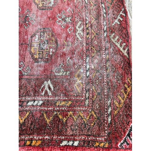 119 - A vintage Bokhara red rug - approx. 103cm x 70cm