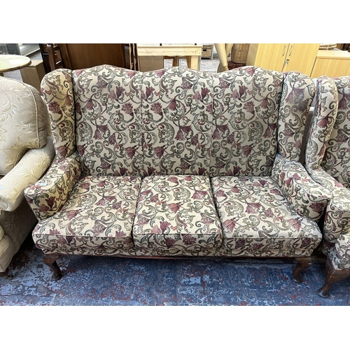 123 - A Georgian style floral upholstered wingback two piece lounge suite comprising three seater sofa and... 