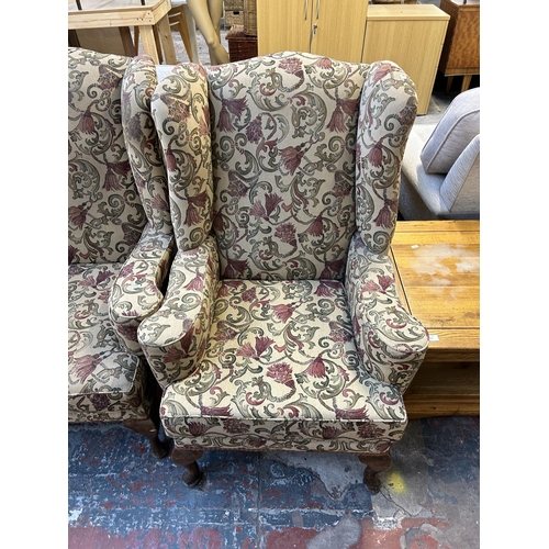 123 - A Georgian style floral upholstered wingback two piece lounge suite comprising three seater sofa and... 