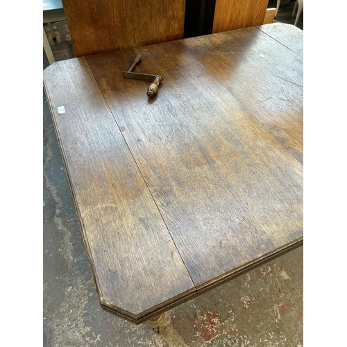 126 - A late 19th century oak rectangular wind out dining table with reeded supports - approx. 71cm high x... 