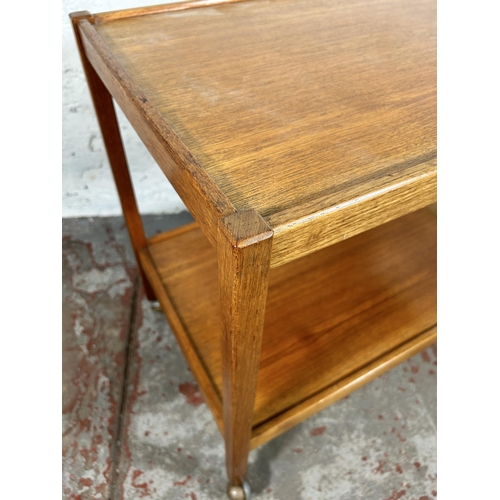 132 - A mid 20th century teak two tier tea trolley - approx. 66cm high x 46cm wide x 71cm long