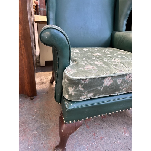 84 - A pair of Parker Knoll PK720/745/1013 green vinyl upholstered wingback armchairs