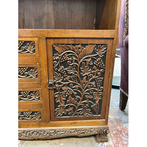 53 - A carved oak cabinet with single cupboard door and four drawers - approx. 87cm high x 71cm wide x 35... 