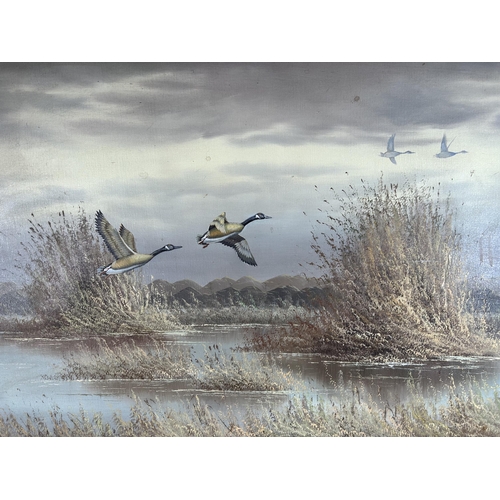 177 - A gilt framed oil on board of Canada geese in flight by H. Monahan - approx. 80cm high x 106cm wide