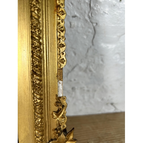 180 - A late 19th/early 20th century gilt framed bevelled edge wall mirror with foliate design - approx. 4... 