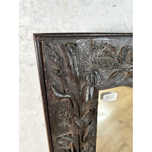 199 - A heavily carved oak framed wall mirror - approx. 44cm high x 34cm wide