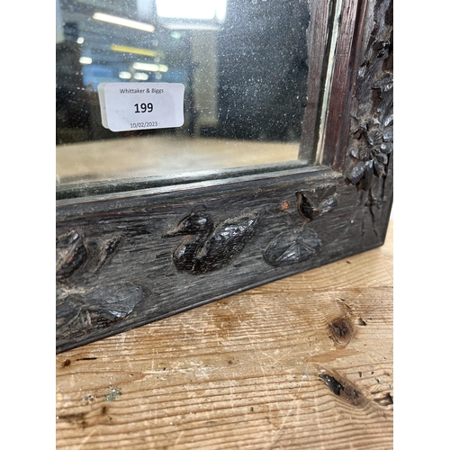 199 - A heavily carved oak framed wall mirror - approx. 44cm high x 34cm wide