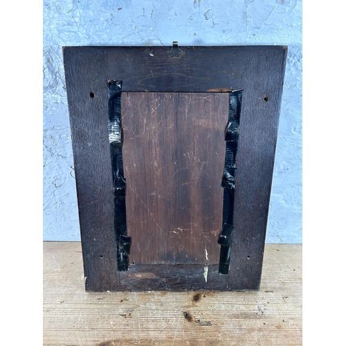 199 - A heavily carved oak framed wall mirror - approx. 44cm high x 34cm wide