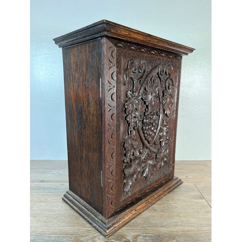 6 - An early 20th century carved oak single door cabinet with foliate and berry design - approx. 45cm hi... 