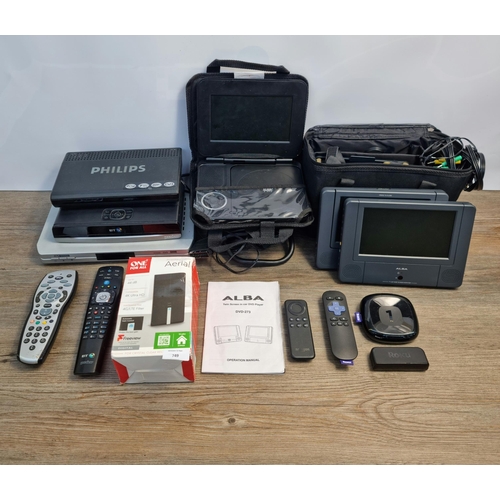 749 - A collection of items to include Roku media streamer, cased Alba portable DVD player, boxed amplifie... 