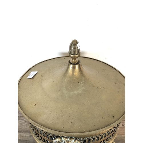 358 - A 19th century pierced brass lidded coal bucket with lion head handles, lion paw supports and acorn ... 