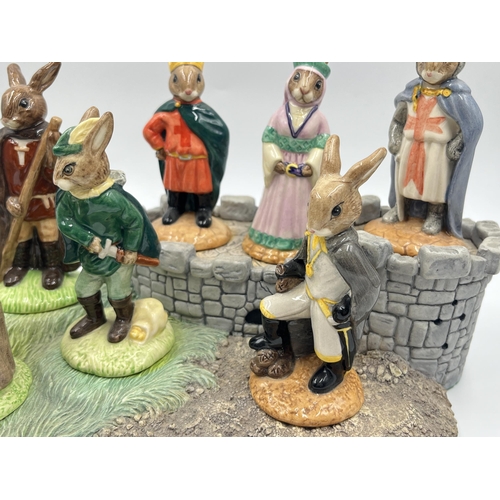 252 - Eight Royal Doulton The Robin Hood Collection Bunnykins figurines together with display base