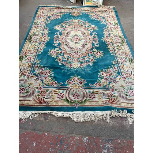 174 - A Chinese floral patterned wool rug - approx. 325cm x 215cm