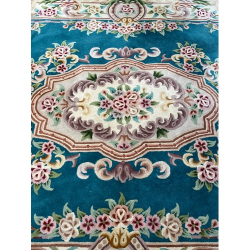 174 - A Chinese floral patterned wool rug - approx. 325cm x 215cm