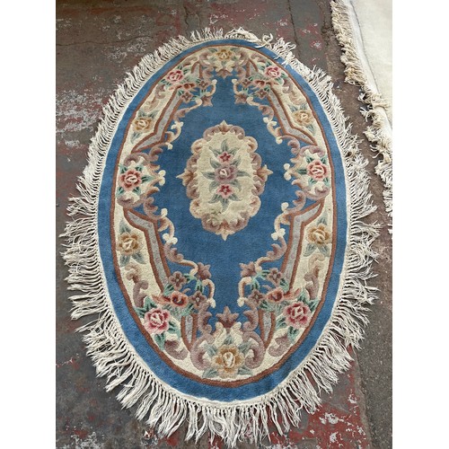 175 - Two Chinese rugs, one 100% wool pile - approx. 290cm x 185cm and one oval blue floral pattern - appr... 