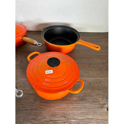 Eight items of good quality cookware to include four Le Creuset wooden