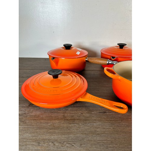 Eight items of good quality cookware to include four Le Creuset wooden