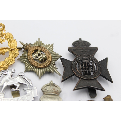 1155 - Ten military cap badges to include Machine Gun Corps, Manchester, Royal New Zealand Infantry Regimen... 