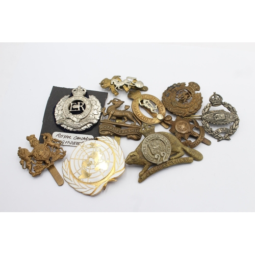 1158 - Ten military cap badges to include Tank Regiment, Nato, Canadian etc.