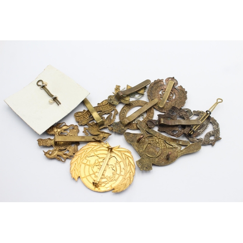 1158 - Ten military cap badges to include Tank Regiment, Nato, Canadian etc.