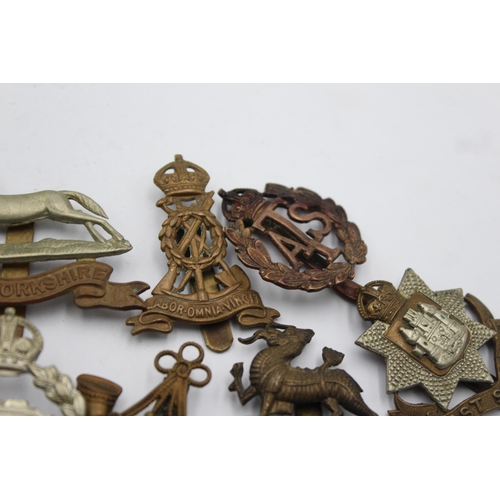 1159 - Ten military cap badges to include West Yorkshire, A.T.S, East Surrey etc.