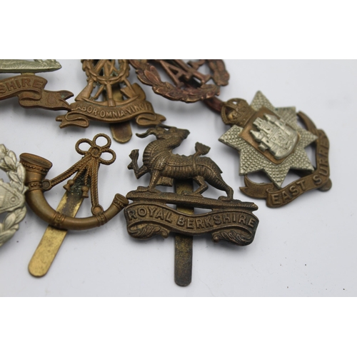 1159 - Ten military cap badges to include West Yorkshire, A.T.S, East Surrey etc.