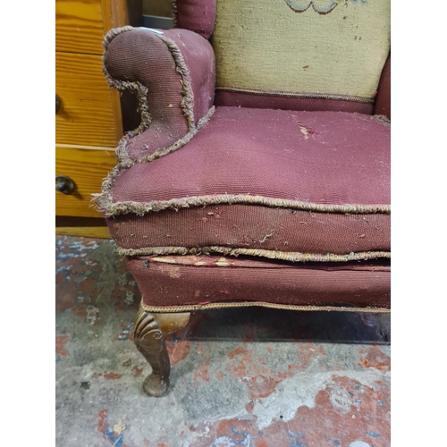 43 - An early/mid 20th century tapestry upholstered wing back armchair with cabriole supports