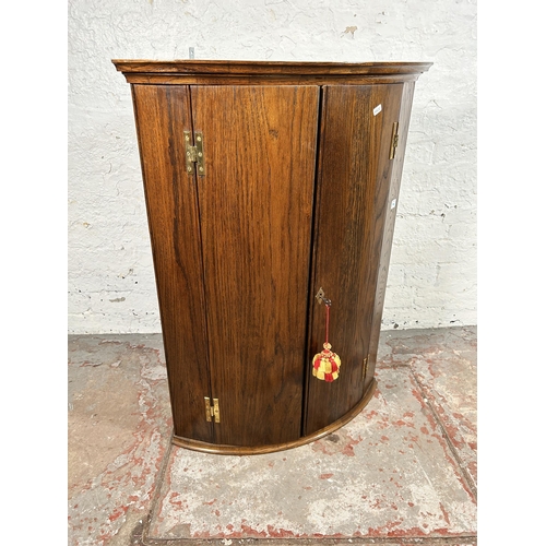 55 - A George III style oak wall mountable corner cabinet with brass 'H' hinges - approx. 90cm high x 67c... 