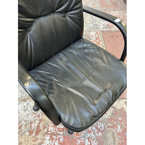 56 - A modern black leatherette and plastic swivel office desk chair