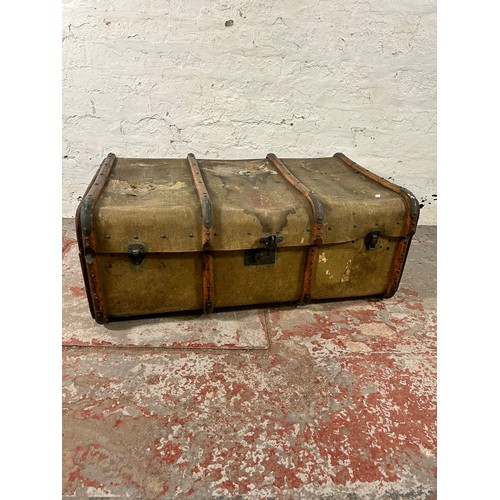 138 - An early 20th century wooden banded canvas travel trunk - approx. 37cm high x 92cm wide x 59cm deep