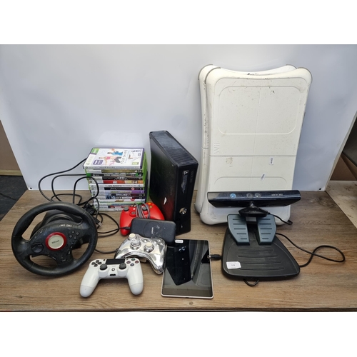 574 - A box containing various gaming accessories and consoles to include Xbox 360 console, PS4 controller... 