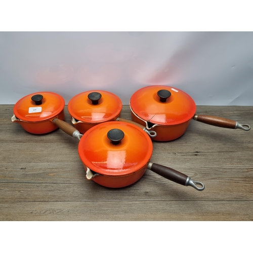 649 - Four orange enamel cast iron Le Creuset lidded saucepans