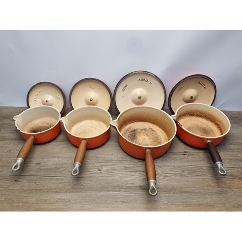 649 - Four orange enamel cast iron Le Creuset lidded saucepans