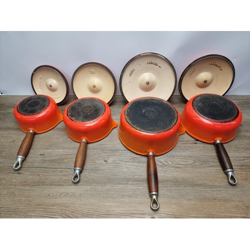 649 - Four orange enamel cast iron Le Creuset lidded saucepans