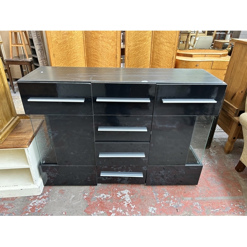 109 - A modern black laminate and glass sideboard with six drawers and two cupboard doors