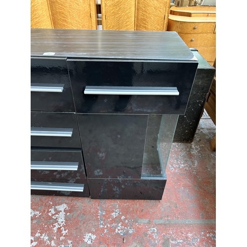 109 - A modern black laminate and glass sideboard with six drawers and two cupboard doors