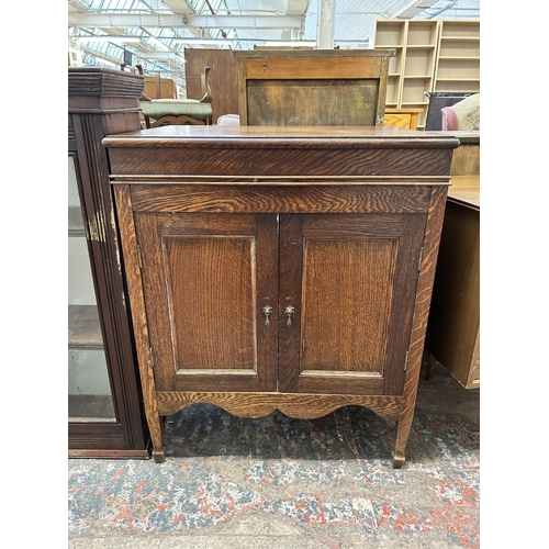 13 - An oak gramophone cabinet with two doors and hinged lid - approx. 86cm high x 70cm wide x 52cm deep