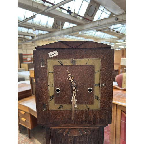 16 - An Art Deco Enfield oak cased chiming grandmother clock with pendulum and key - approx. 148cm high x... 