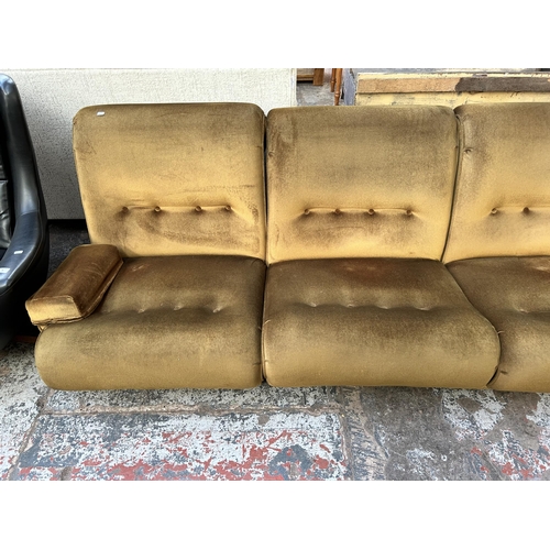 72 - A mid 20th century green fabric upholstered two piece lounge suite comprising modular four seater so... 