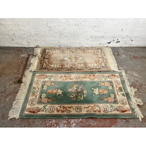 73 - Two Chinese tasselled rugs - largest approx. 140cm x 70cm