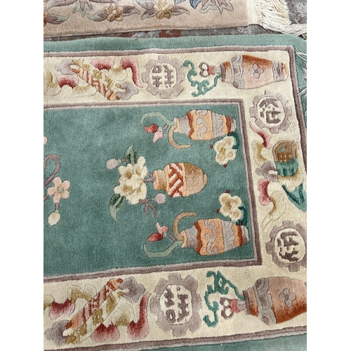 73 - Two Chinese tasselled rugs - largest approx. 140cm x 70cm
