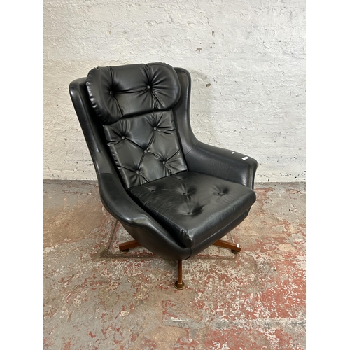 74 - A mid 20th century black vinyl swivel armchair on teak base - approx. 95cm high x 88cm wide x 77cm d... 