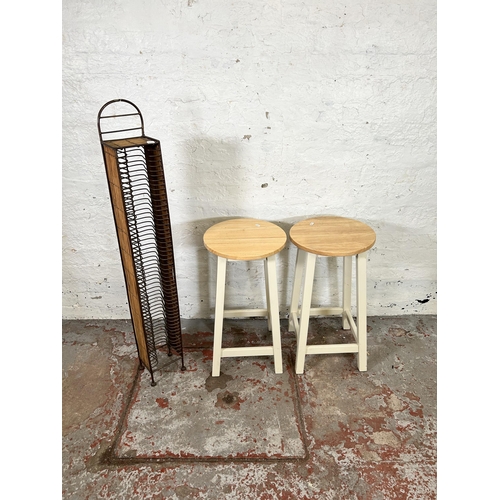 79 - Three pieces of furniture, two beech and white painted barstools and one wicker and metal CD rack