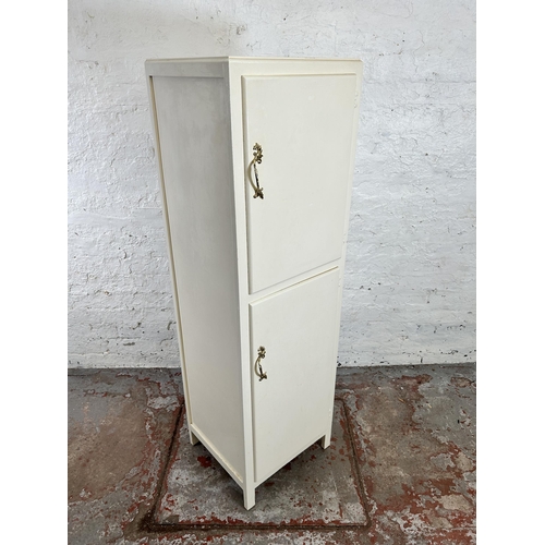 81 - A late 20th century white painted two door cabinet - approx. 140cm high x 43cm wide x 39cm deep