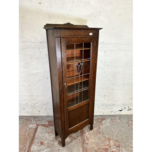 99 - An early 20th century oak display cabinet with single leaded and stained glass door and five interna... 