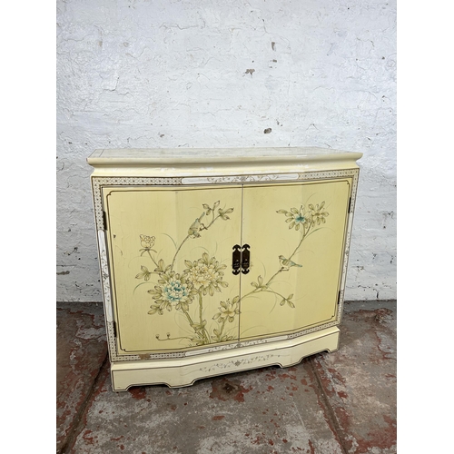 28 - An Oriental style cream lacquered two door cabinet with bird and foliate design - approx. 73cm high ... 