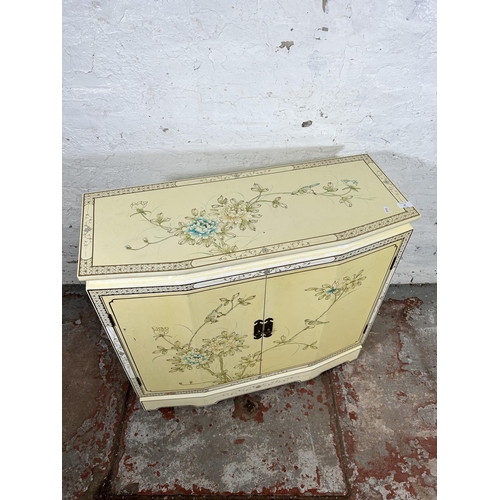 28 - An Oriental style cream lacquered two door cabinet with bird and foliate design - approx. 73cm high ... 