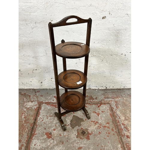 30 - An early 20th century oak three tier folding cake stand - approx. 80cm high