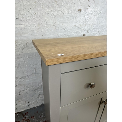 49 - A modern oak effect and dove grey painted sideboard with two drawers and two cupboard doors - approx... 